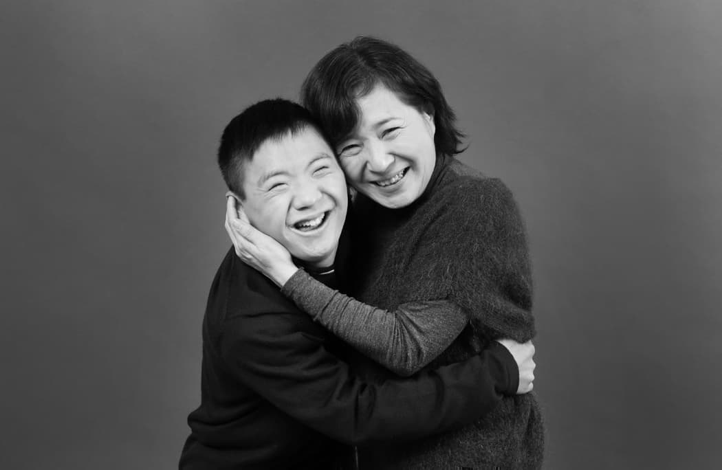 抱き合うダウン症の息子と母