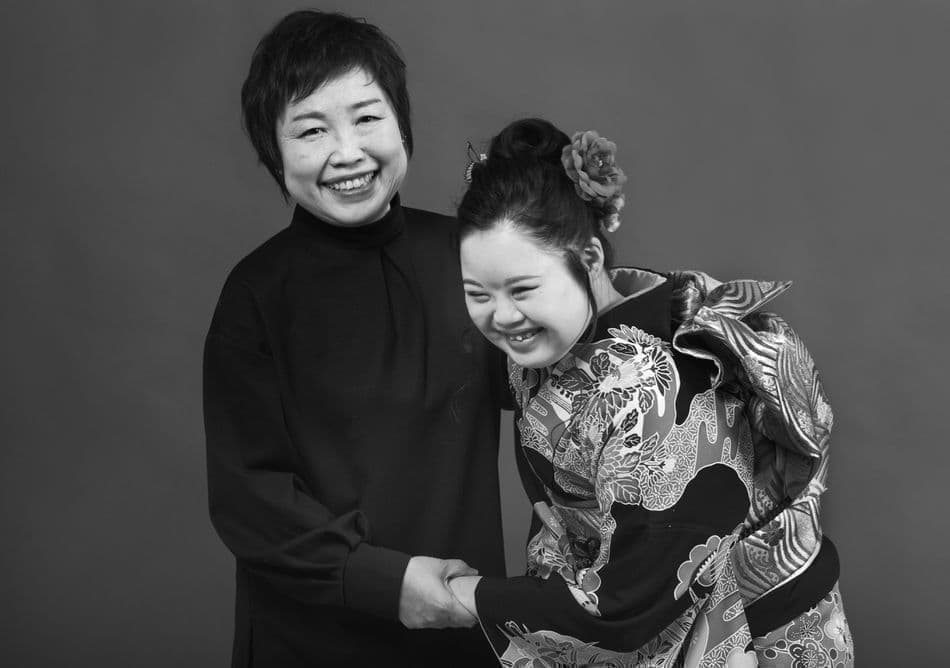成人式のダウン症の女性と笑う母親