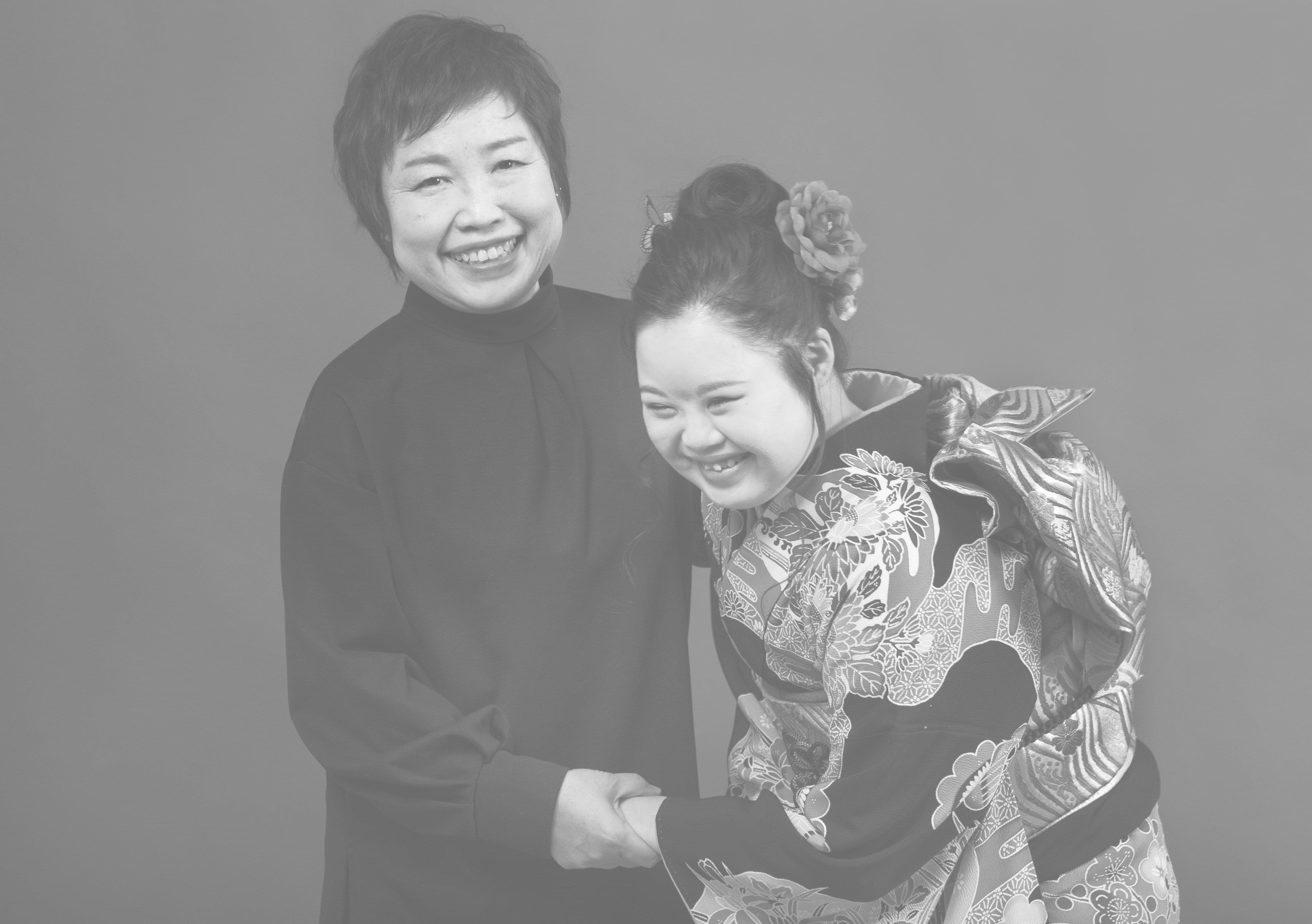 成人式のダウン症の女性と笑う母親