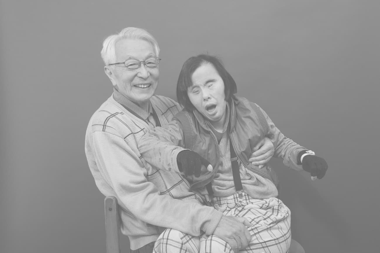 ダウン症の娘を抱く父