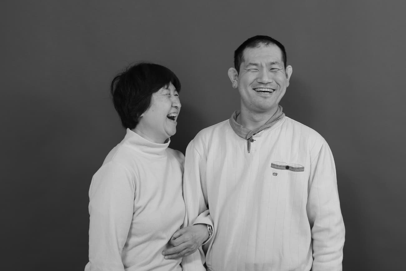 発達障害の息子と腕を組み笑う母
