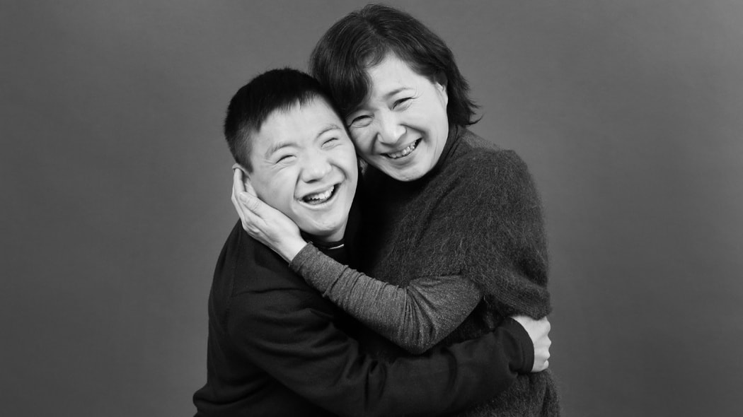 写真スタジオで子供をあやすカメラマンとアシスタント